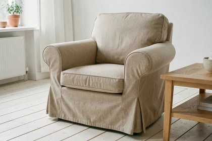 Housse sur mesure en lin beige ajustée sur un petit fauteuil dans un salon scandinave aux tons naturels