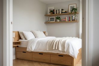 Petite chambre optimisée avec lit plateforme à tiroirs de rangement intégrés et étagères murales flottantes